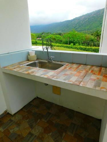 a kitchen sink with a view of a mountain at Casa Vacacional - Portales del Sol 2 in Tocaima