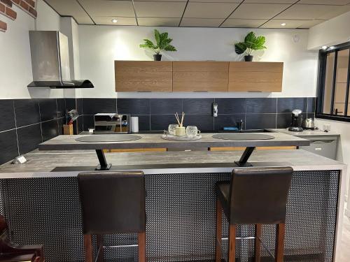 a kitchen with a counter with two sinks and two chairs at LE GARIBALDI - CENTRE VILLE - parking privatif in Limoges