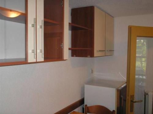 a kitchen with wooden cabinets and a refrigerator at Apartment Nono Anton in Kraljevica