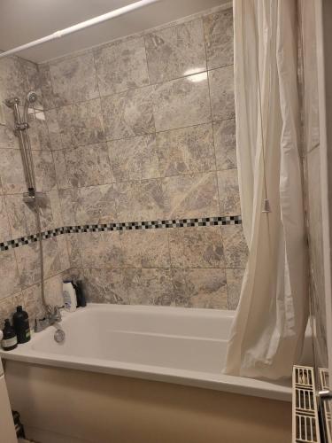 a bathroom with a bath tub with a shower curtain at Residence Solitaire in Woodley