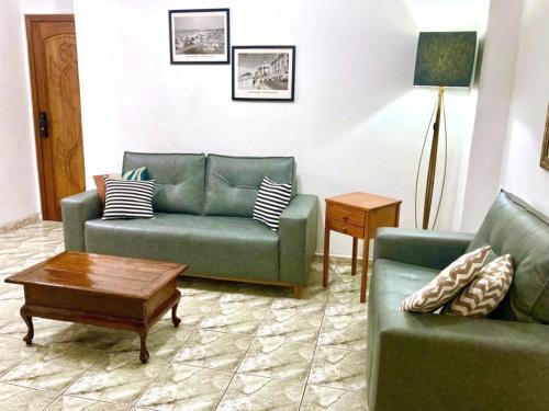 a living room with two couches and a coffee table at Edificio ALONE com terraço na quadra da praia, espaçoso e silencioso in Rio de Janeiro