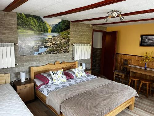 een slaapkamer met een bed en een schilderij aan de muur bij POKOJE GOŚCINNE U ANIELI Szczyrk Biały Krzyż in Szczyrk