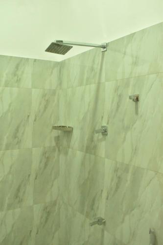 a bathroom with white marble walls and a ceiling at The Opulent Retreat in Ahangama