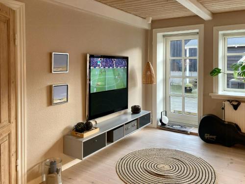 a living room with a flat screen tv on a wall at True Skagen House From 1870 By The West Coast in Skagen