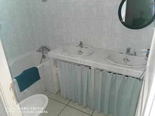 une salle de bain avec deux lavabos et une baignoire et des toilettes dans l'établissement Maison confortable avec jardin à Marseille, à Marseille
