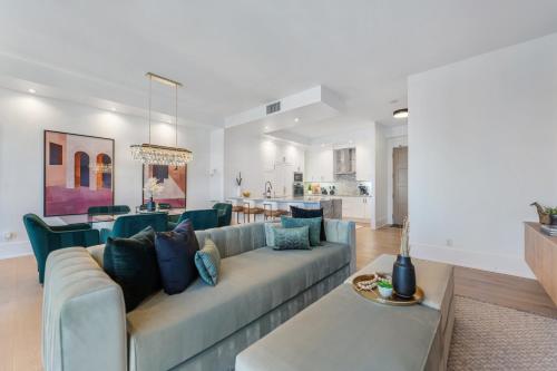 ein Wohnzimmer mit Couch und Küche in der Unterkunft Rosewood Skyline Penthouse - CN Tower Views, Downtown Toronto in Toronto