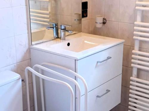 une salle de bains avec un lavabo blanc et un miroir dans l'établissement Chalet rénové Les Gets 8 pers, central, 150m commerces, 350m pistes, terrasse sud, parking privé - FR-1-802-84, aux Gets