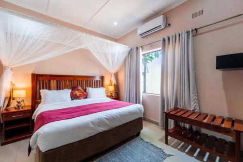 een slaapkamer met een groot bed en een raam bij Victoria Falls Premier Lodge in Victoria Falls
