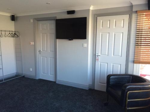 a room with two doors and a television on the wall at Links Lets Room Only in Seahouses