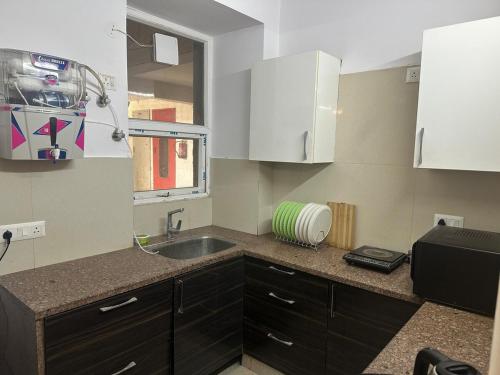 a small kitchen with a sink and a window at Taj Nidhi Luxury in Agra