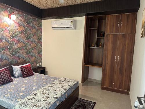 a small bedroom with a bed and a cabinet at Taj Nidhi Luxury in Agra