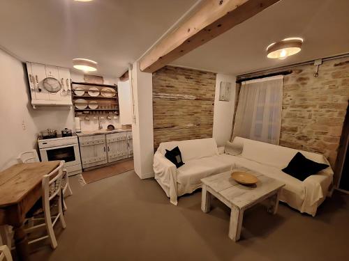 een woonkamer met een witte bank en een tafel bij balconi 1911 - Traditional house in Ydroussa, Samos in Ydroússa