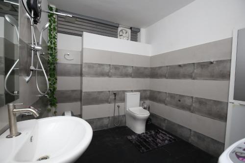 a bathroom with a white sink and a toilet at Ideal Residence in Matara