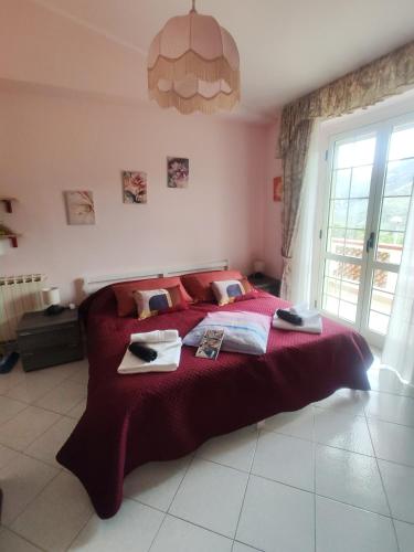 a bedroom with a large bed with a red blanket at Vicky's B&B by V in Papasidero