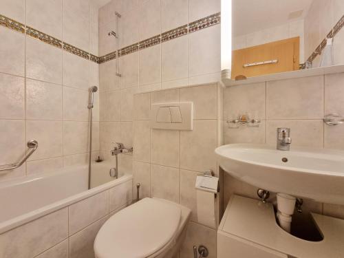 Un baño blanco con inodoro y lavabo. en Dominic A2, en Saas-Fee