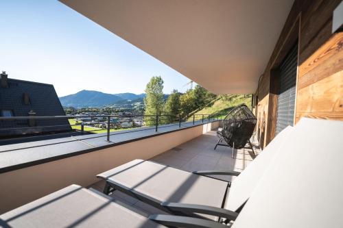 a balcony with a table and chairs and mountains at Nestzeit in Eben im Pongau