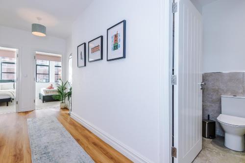 een badkamer met witte muren en een toilet in een kamer bij Modern Leeds Central Stay -2 min walk from station in Leeds