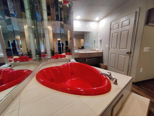 een badkamer met een groot rood bad in het midden bij Regency Inn & Suites By Capital O Houston IAH Airport in Humble