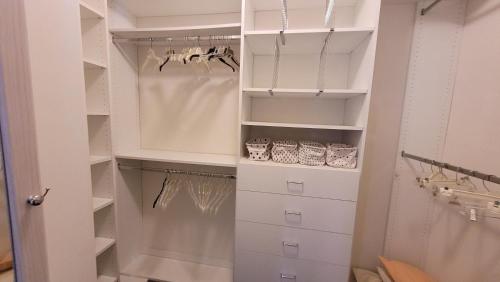 einen begehbaren Kleiderschrank mit weißen Schränken und Schubladen in der Unterkunft Azure Elephant Haven Quiet, Welcoming Vibe in Middletown