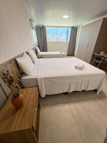 a bedroom with two beds and a couch at Amaliê Pousada in Barra de São Miguel