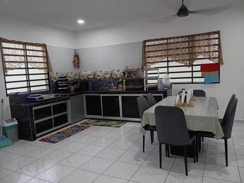 a kitchen with a table and chairs in a room at Balqis LN Homestay in Taiping