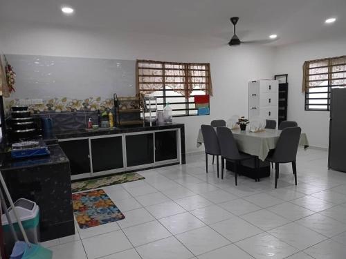 a kitchen with a table and chairs in a room at Balqis LN Homestay in Taiping