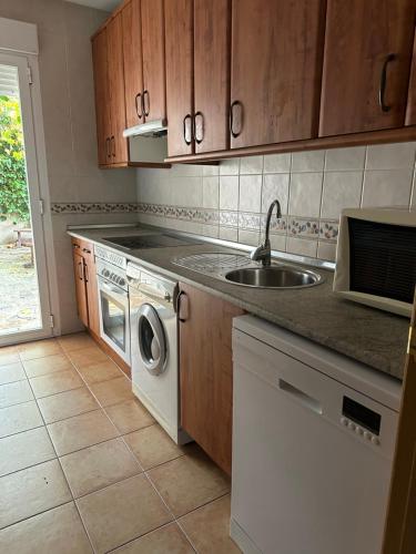 a kitchen with a sink and a washing machine at Casas Encinares in Narrillos de San Leonardo