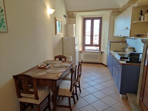 a kitchen with a table and chairs and a kitchen with a refrigerator at Dimora Fenni in Monte Isola