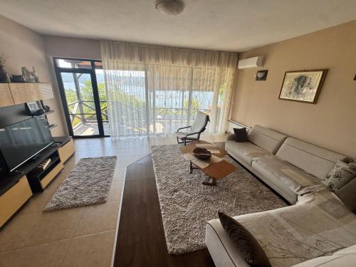 a living room with a couch and a television at Penev guest house in Glavatartsi