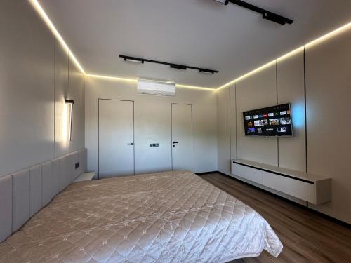 a bedroom with a bed and a tv on the wall at Видова смарт-квартира в ЖК City Park in Cherkasy