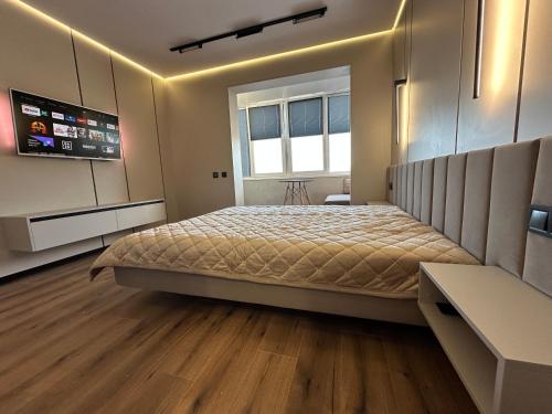 a bedroom with a large bed and a window at Видова смарт-квартира в ЖК City Park in Cherkasy