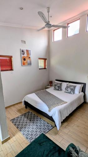 a bedroom with a bed with a ceiling fan at Luxury Studio in Fourways in Sandton
