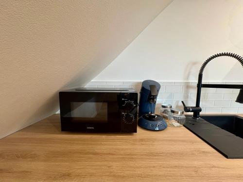 Un microondas colocado encima de una encimera de cocina. en Le Cocon Arras Centre & Netflix 4 pers, en Arras