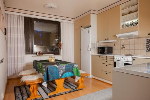 una cucina con un tavolo e una cucina con un fornello di Kitka riverview retreat with sauna a Kuusamo