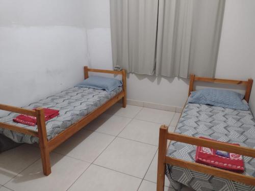 two beds in a small room with at Casa Com Lazer 8 anos in Cidade Ocidental