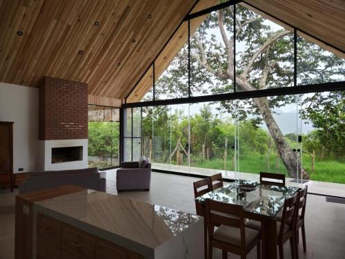 a living room with a table and chairs and a large window at Casa Francis Oxapampa in Oxapampa