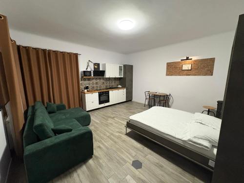 Un dormitorio con una cama y un sofá verde. en Airport Green, en Cluj-Napoca