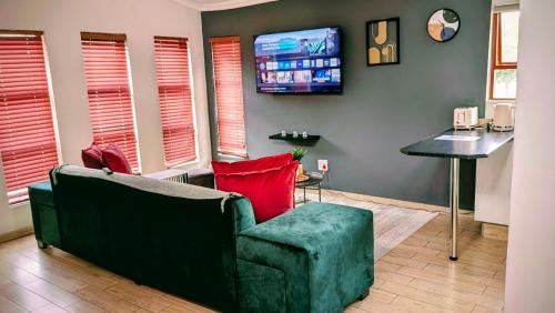 a living room with a couch and a flat screen tv at Luxury Studio in Fourways in Sandton