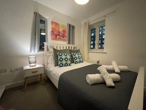 a bedroom with a bed and a table with a lamp at Hawksbill 3 Bed Detached house with private parking in Peterborough