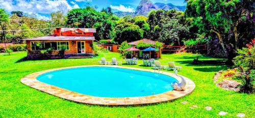a swimming pool in the yard of a house at Pousada dos Chalés - Araras in Araras Petropolis