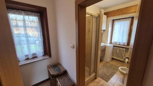 une pièce avec un couloir avec des toilettes et une fenêtre dans l'établissement Ca' Piloni appartamento con 3 camere, à Pieve di Cadore