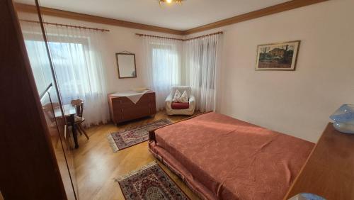 une chambre avec un lit, un bureau et une chaise dans l'établissement Ca' Piloni appartamento con 3 camere, à Pieve di Cadore