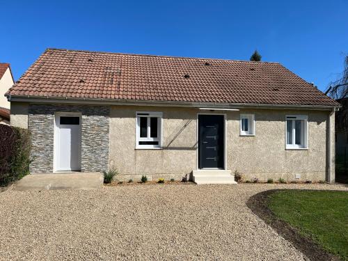 a brick house with a brown roof at La maison d a cote in Éguzon-Chantôme
