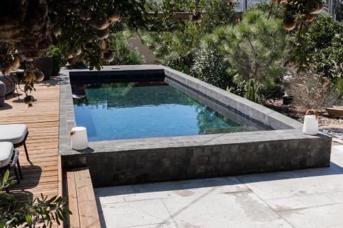 a swimming pool in a garden with a retaining wall at BURGUNDY house in Grândola