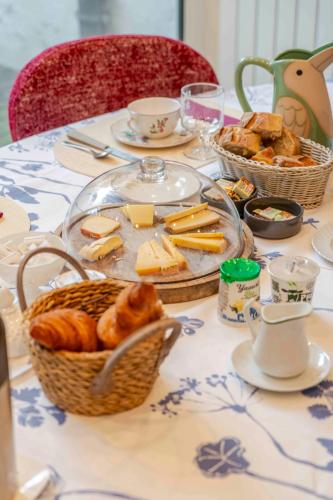una mesa con cestas de pan y bollería. en Chez Marie, en Dunkerque