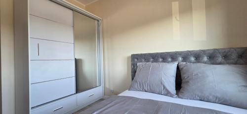 a bedroom with a mirror and a bed with white pillows at Apartament Srebrny Quick Park Oława in Oława