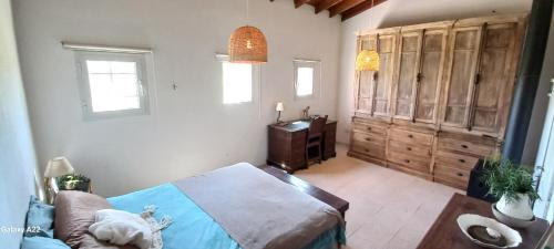 een slaapkamer met een bed en een houten kast bij La Chacra in Pilar
