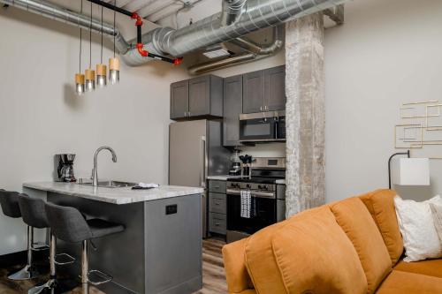 a kitchen with a couch and a table in a room at Modern City View 1BR Apartment with Office - free parking in Appleton
