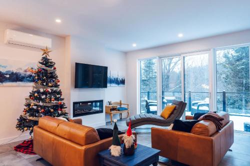 una sala de estar con un árbol de Navidad. en Le Yéti de Tremblant, en La Conception