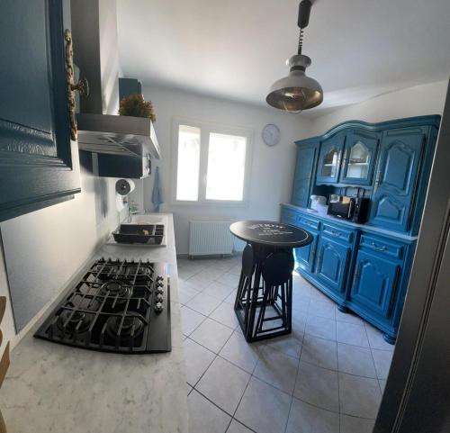 a kitchen with a stove and a blue cabinet at 2 chambres dans Appartement cozy in Rodez
